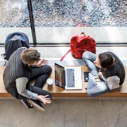 Students meet with a laptop and coffee in Goodes Hall