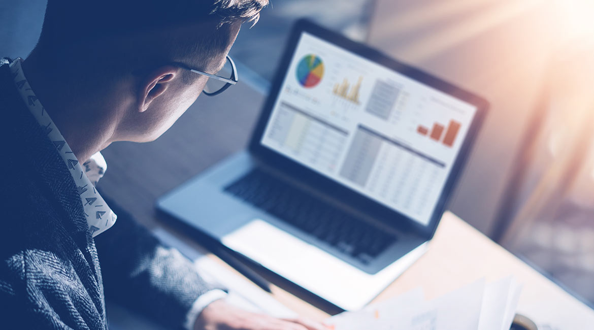 man looking at data on laptop