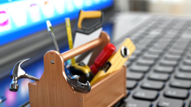 Toolbox with tools on laptop keyboard.