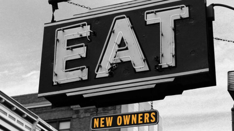 A vintage sign reading EAT and NEW OWNERS