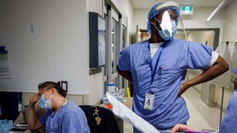 A nurse holds her head as nurses care for patients suffering from COVID-19 at Humber River Hospital's Intensive Care Unit, in Toronto, Ontario on April 28, 2021. 