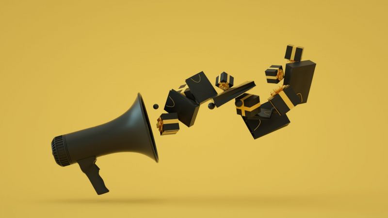Black Friday concept. 3D rendering of a black megaphone with flying black gift boxes and shopping bags