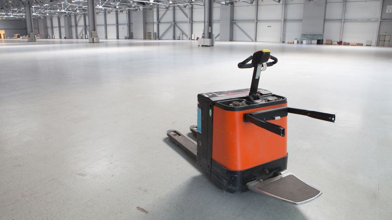 Electric forklift in large modern storehouse with some goods