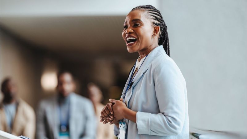 Professional African woman engages attendees as she speaks at a business conference