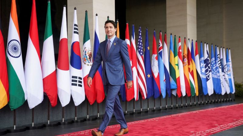 Prime Minister of Canada Justin Trudeau on the red carpet, flags of different countries on the background