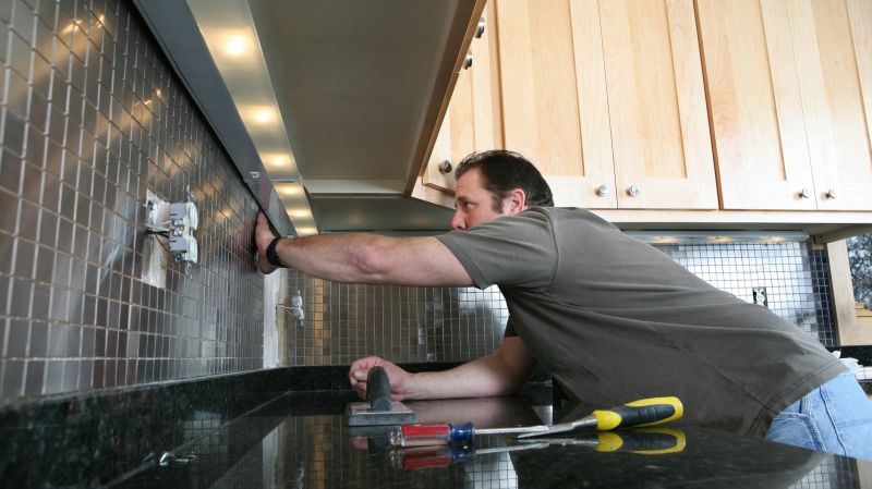 A man changes the tiles in the kitchen