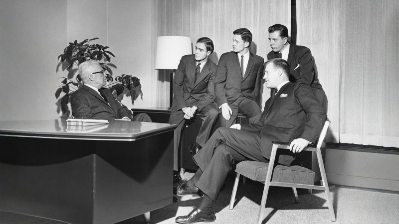 1950s style black and white photo of men in an office meeting
