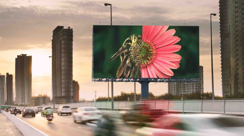 An photo of a flower on a billboard in a city