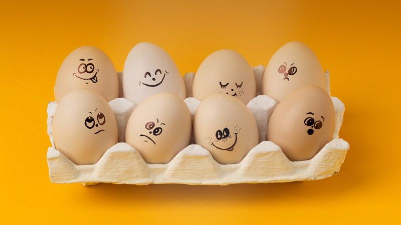 Eggs in a carton with faces painted on them depicting different emotions
