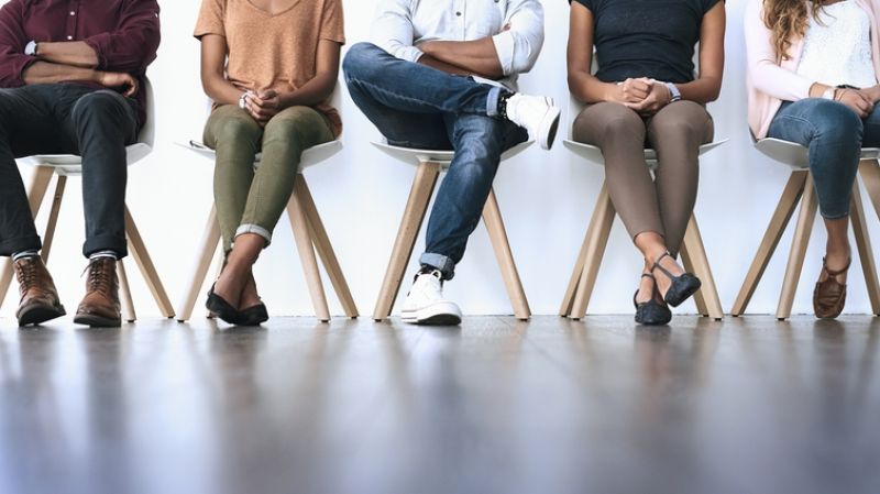 A group of diverse people waiting in line to be interviewed.