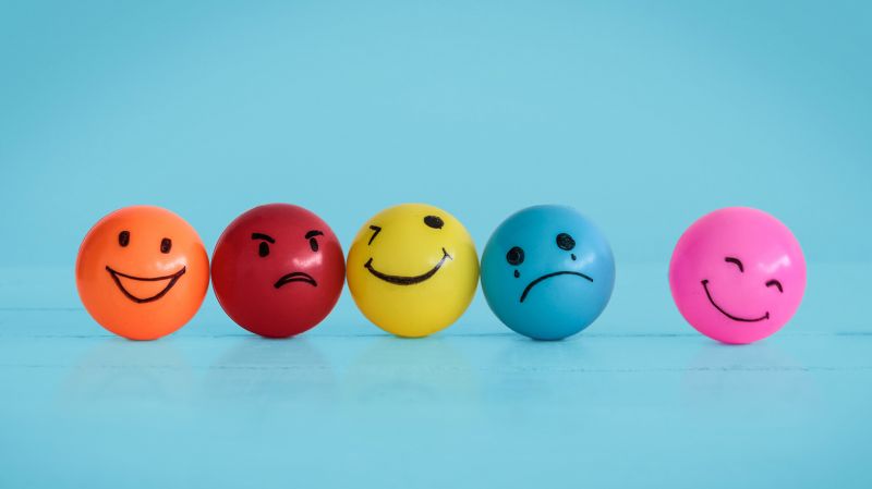 Different coloured bouncy balls with range of emotions drawn on them.