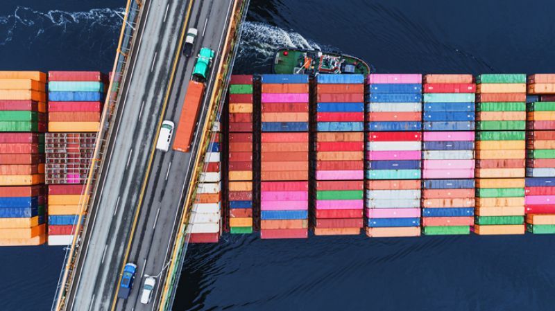 A container ship passes beneath a suspension bridge as it departs for Europe.