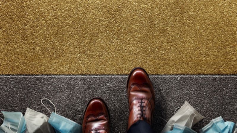 Businessman shoes steps into the office with used masks discarded on the floor. 