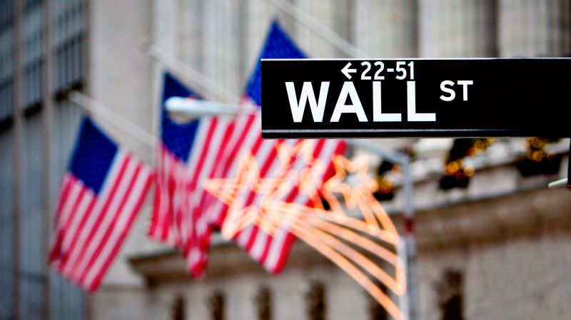 Wall Street sign in New York with New York Stock Exchange background.