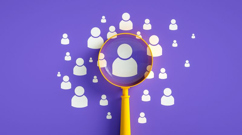 Yellow magnifying glass and figures of people on a purple background