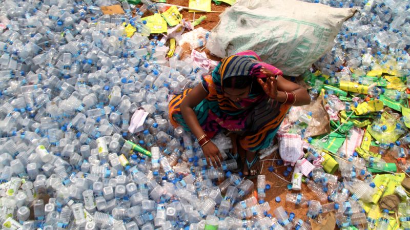 NEW DELHI, INDIA - June 04, 2020: A woman collects empty plastic bottles.