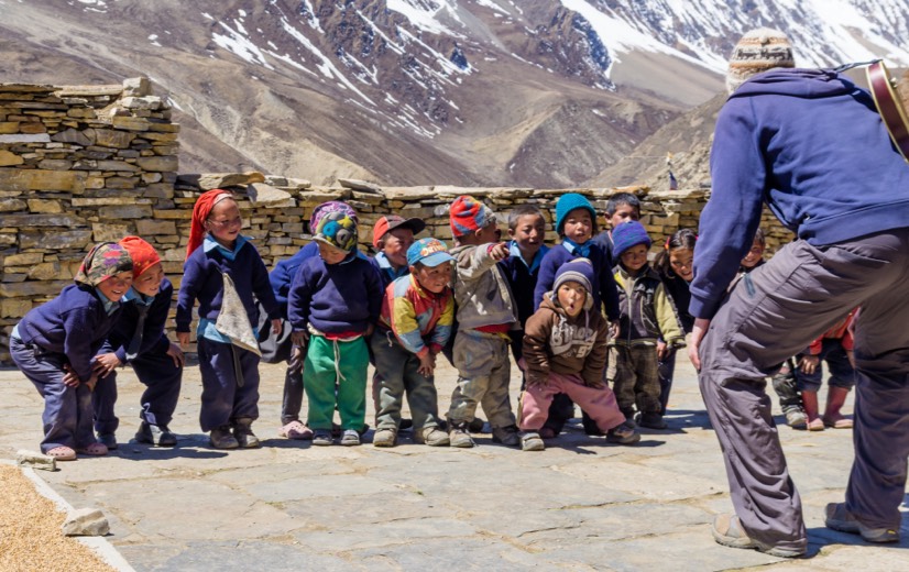 Mike Schauch in the mountains of Nepal and children playing in Nar village