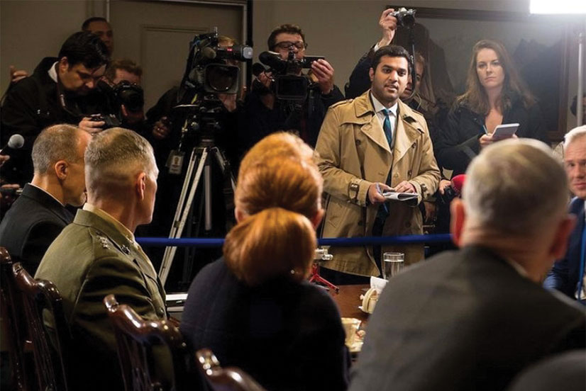 Idrees Ali stands in front of a group of journalists as he states a question to members of the Pentagon in the foreground.