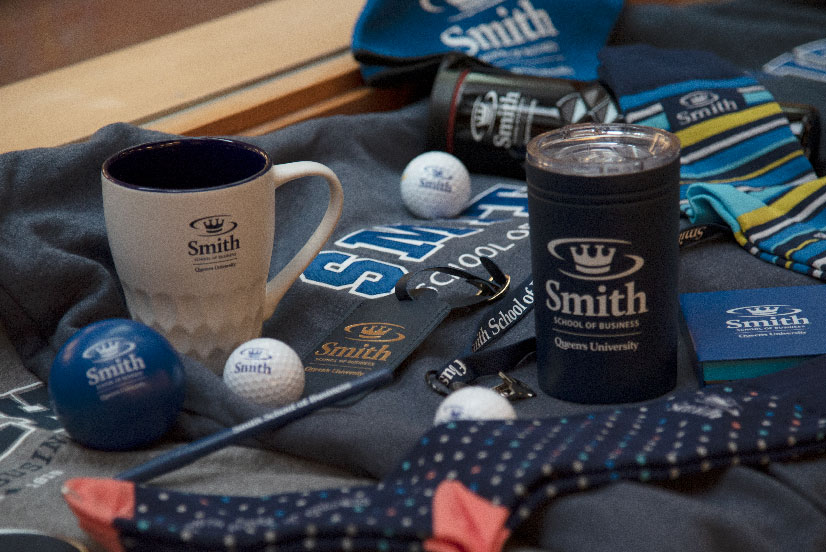A collection of Smith swag, including sweaters, socks, mugs, and golf balls
