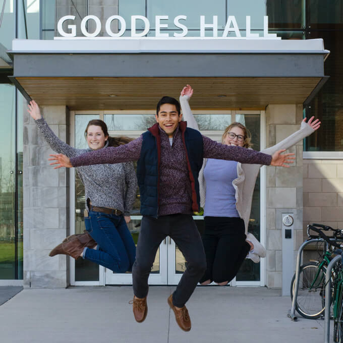 Students jump outside in front of Goodes Hall