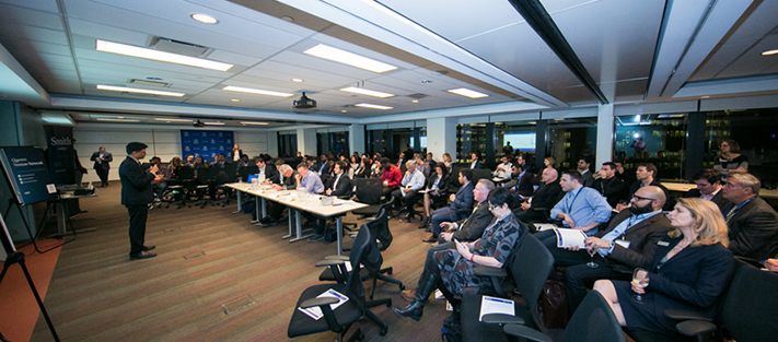 Kiran Manjunath, MBA’10, pitches CoinValue, a coin sorter that can distinguish extremely similar coins, to the judges and Queen’s student and alumni spectators.   