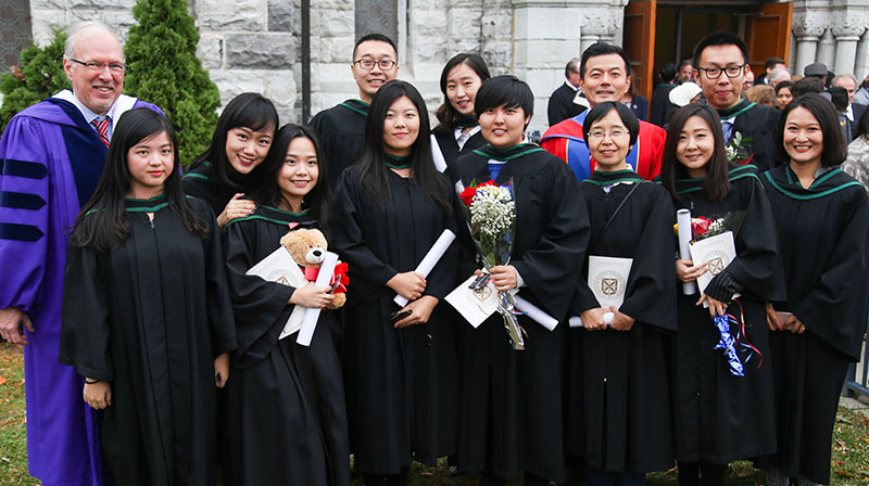 Students from Smith's Master of Finance - Beijing, joined by Dean David Saunders, Academic Director Wei Wang, and Assistant Director Aileen Dong, celebrate following the Nov. 14 convocation ceremony at Grant Hall.