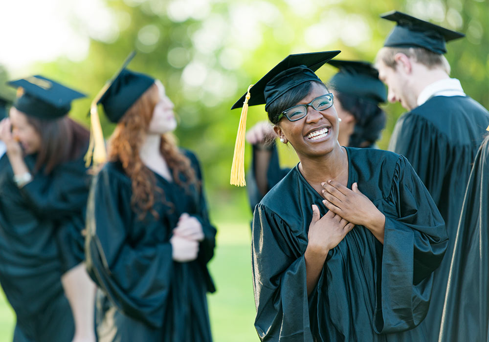 Students celebrating their graduatiion wearing caps and gowns