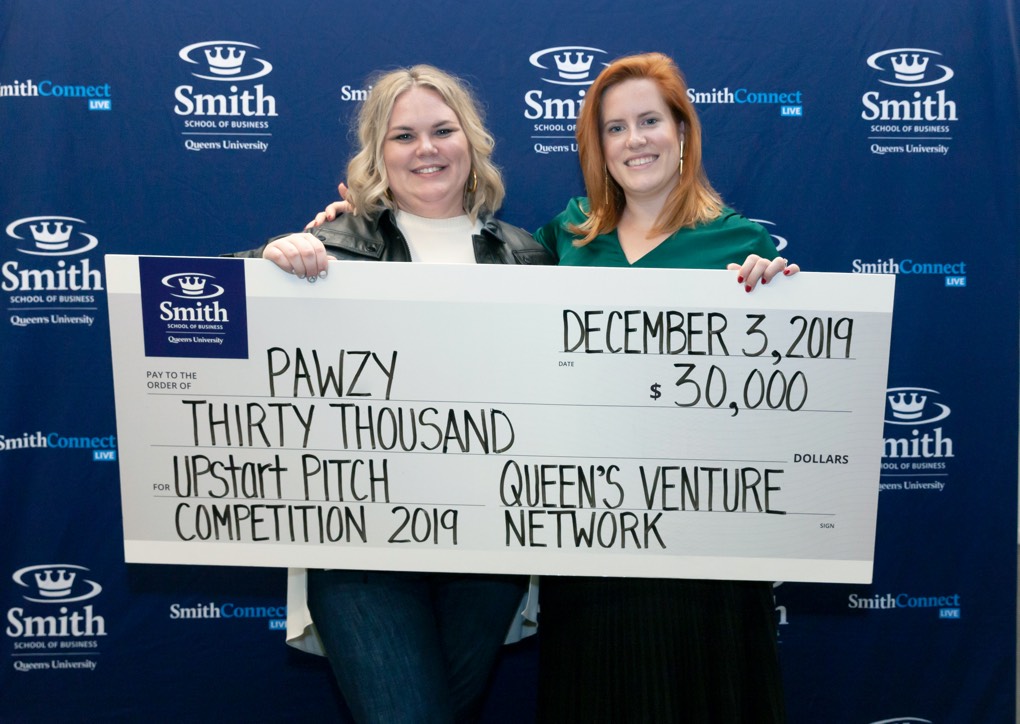 The winners of the pitch competition holding a cheque for $30,000